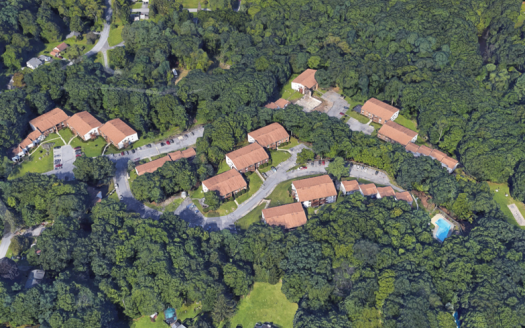 Aerial view of condominium complex with pool