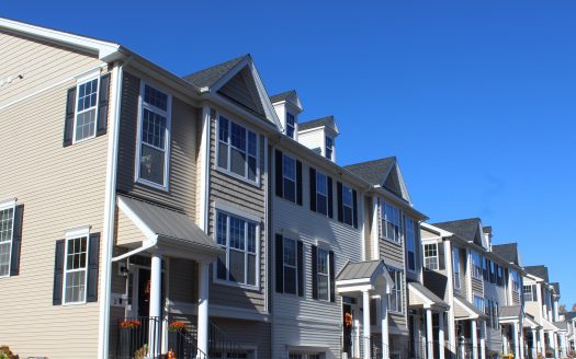 Row of condominium units with blue sky background