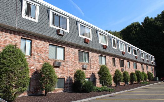 Brick condominium building with mulch and trees in Danbury, Connecticut